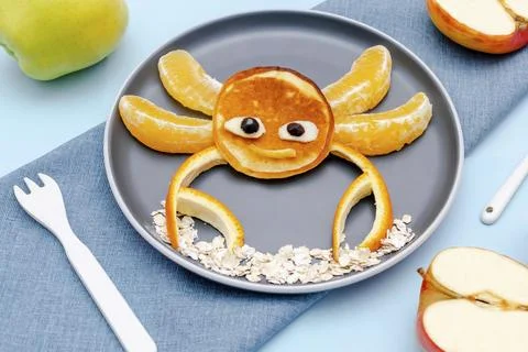 Funny crab face shape snack from pancake, orange,apples on plate. Cute kids Stock Photos