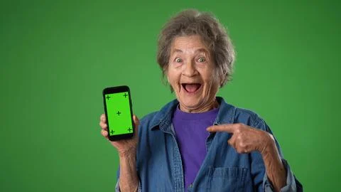 Funny crazy elderly old toothless woman posing with phone with green screen Stock Photos