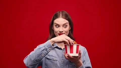 Funny crazy face. Emotional young girls eating fried chicken with hot chilli Stock Footage 242723241