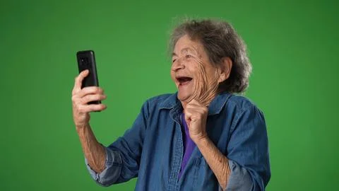 Funny crazy happy elderly old toothless woman taking selfie using mobile cell Stock Photos