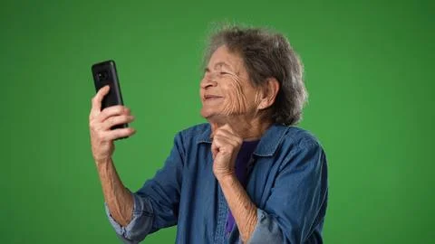 Funny crazy happy elderly old toothless woman taking selfie using mobile cell Stock Photos
