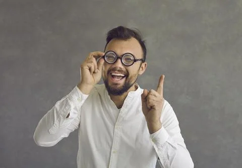 Funny crazy looking nerd in glasses has a brilliant idea and points his finger Stock Photos