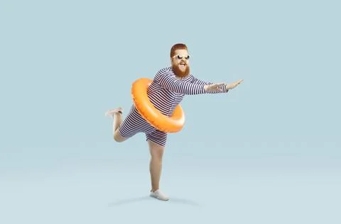 Funny crazy man with inflatable circle pretends to float on light azure Stock Photos