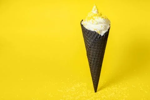 Funny creative concept of vanilla soft serve ice cream in black wafer cone wi Foto stock