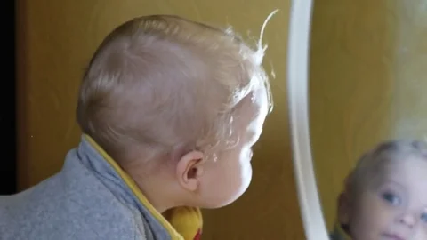 Funny cute 9-10 months old baby boy looking in mirror Stock Footage 82392038
