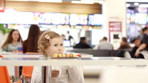Funny cute child in a cafe eating food - dessert pancakes with sweet stuffing Stock Footage 82436637