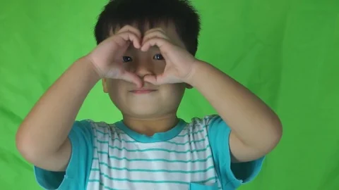 Funny cute little boy makes shape of heart with hands 스톡 동영상 74606918