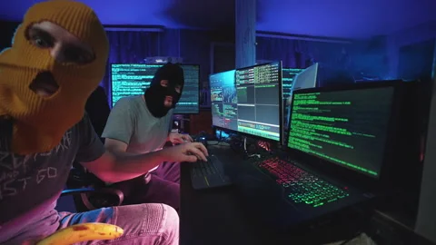 Funny cyber hackers coding on computer or men in masks hacking program on laptop Stock Footage 266382095