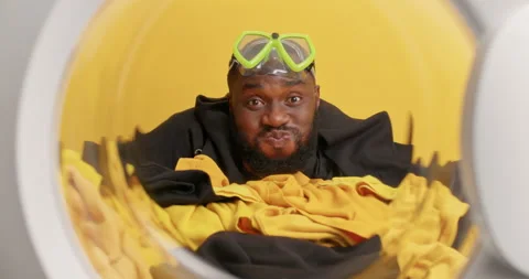 Funny dark skinned bearded man holds breath dives in washing machine with water Stock-Footage 156633470