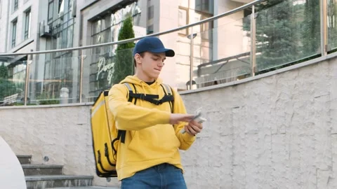 Funny delivery man scatter the dollars and dancing on the stairs. Money rain Stock Footage 156965629