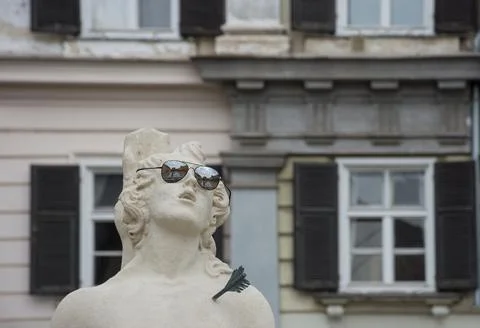 Funny detail of a statue of the Trinity Column with sun glasses in Karmeliter Stock Photos