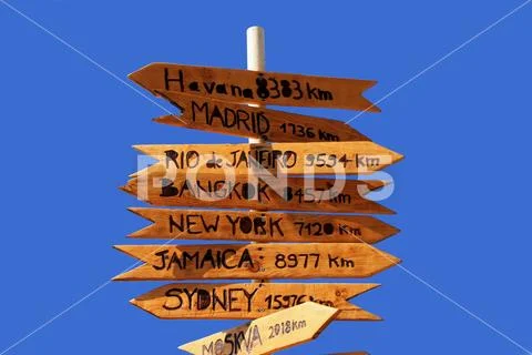 Funny direction signpost with distance to many different cities in the world Stock Photos