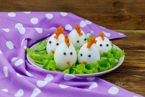 Funny easter breakfast with boiled eggs as chicks on wooden table Stock Photos