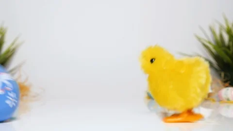 Funny Easter, Easter egg rolls on the table, toy chick follows him Stock-Footage 123602633