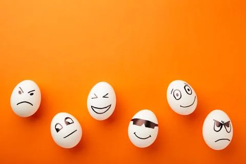 Funny Easter eggs with different emotions on his face on orange background. E Stock Photos