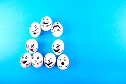 Funny easter eggs with different funny faces on blue background with copy spa Stock Photos