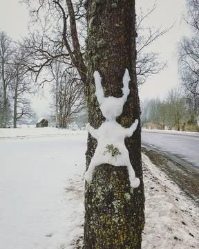 Funny Easter joke. An Easter bunny made of snow, which is struck by a tree wi Stock Photos