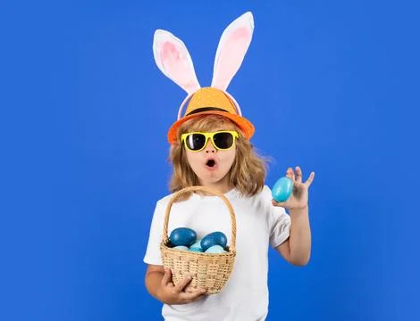 Funny easter kid. Portrait of cute child with bunny ears hold easter basket with 写真素材