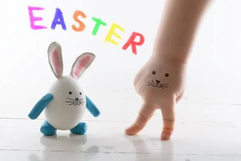 Funny easter rabbit and child hand with cute face. Face painted on a child'.. Stock Photos