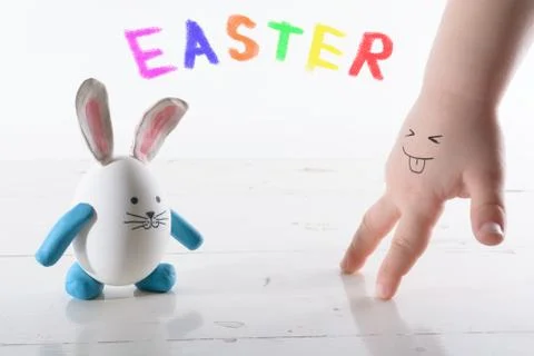 Funny easter rabbit and child hand with sly face. Face painted on a child's.. Stock Photos