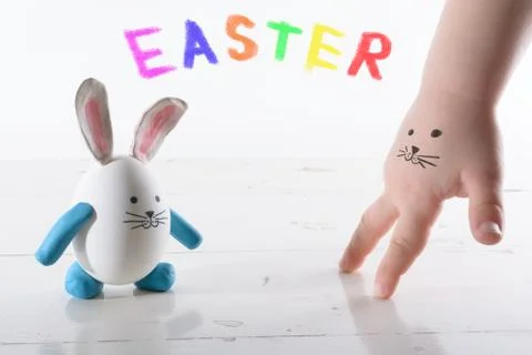 Funny easter rabbit and child hand with cute face. Face painted on a child'.. Stock Photos