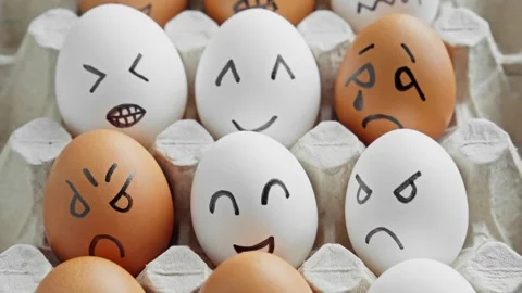 Funny eggs with smiling faces. Chicken eggs in container. Brown and white eggs Stock Footage 303266601