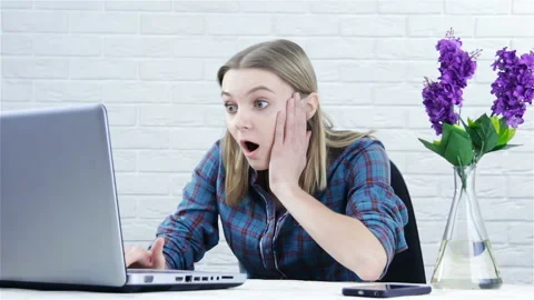 Funny emotional girl learning online on laptop . Shocked woman working in off Stock Footage