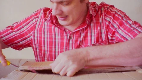 Funny emotional man opens the parcel Stock Footage 86538677