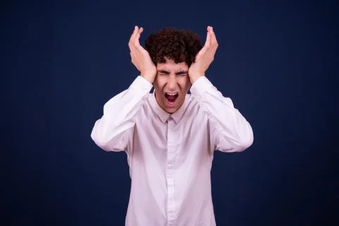 Funny emotions of an attractive guy. Blue background. Stock Photos