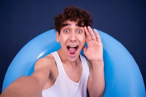Funny emotions of an attractive guy. Blue background. Stock Photos