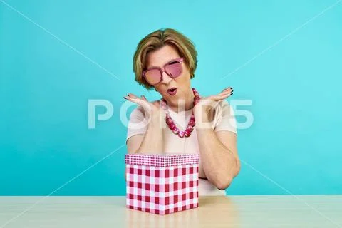 Funny excited old woman. A woman in age was very happy to receive gifts. holding Stock Photos