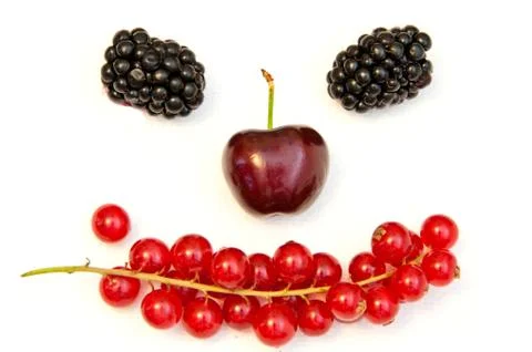 Funny face from different berries on a white background Stock Photos