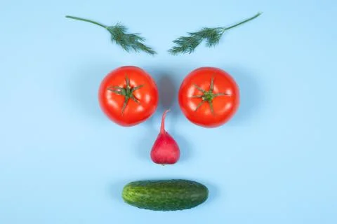 Funny face from different vegetables tomatoes, cucumber, radish, dill and ros Stock Photos