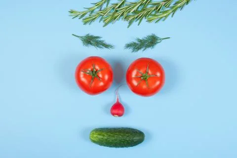 Funny face from different vegetables tomatoes, cucumber, radish, dill and ros Stock Photos