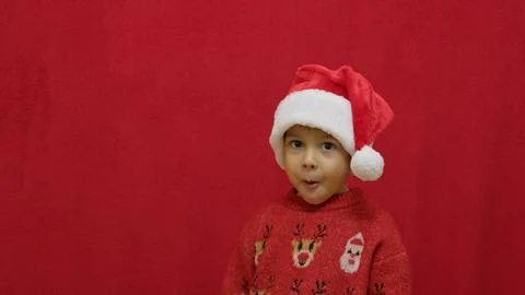 Funny face expression of a cute preschool boy with christmas sweater and santa Stock Photos