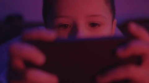Funny face small boy looks at a smartphone before going to bed in a dark room Stock Footage 127168870