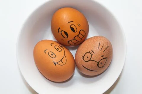 Funny faces drawn on eggs Stock Photos