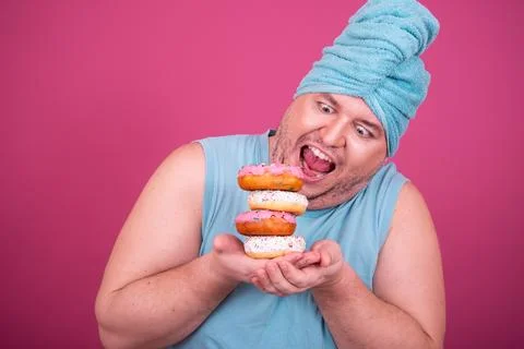 Funny fat man eats donuts. Retro style. Food and fitness. Stock Photos