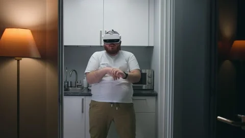 Funny fat man in virtual reality glasses dance in small kitchen Stock Footage 195082804