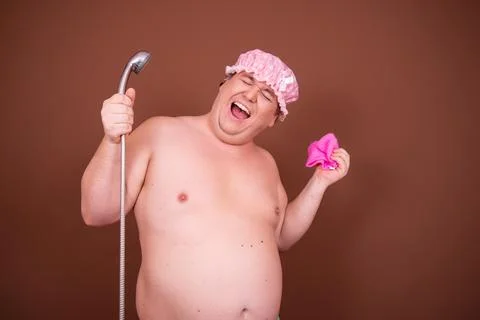 Funny fat man is washing himself in the shower. Stock Photos