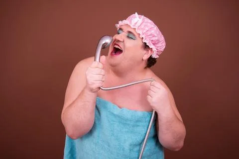 Funny fat man is washing himself in the shower. Stock Photos