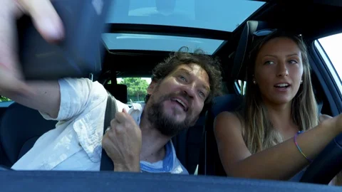 Funny father and daughter while driving car taking picture with cell phone af Stock Footage 129909403