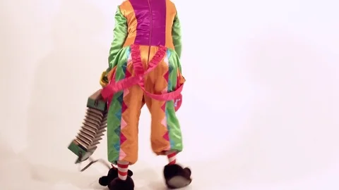 Funny female clown dancing in a comical way against white background Видео 70510967