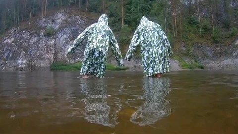 Funny flex in camouflage raincoats. Two teenagers perform synchronized dance Stock Footage 112294008