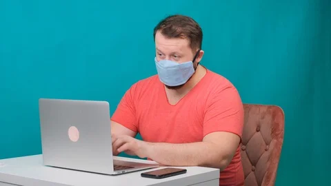 Funny frames of male using laptop. man working on a computer in a protective Stock Footage 128767460