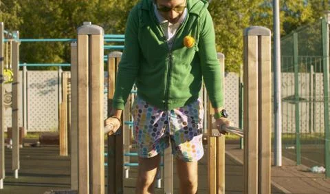 Funny freak man pushing up on parallel bars Stock Photos
