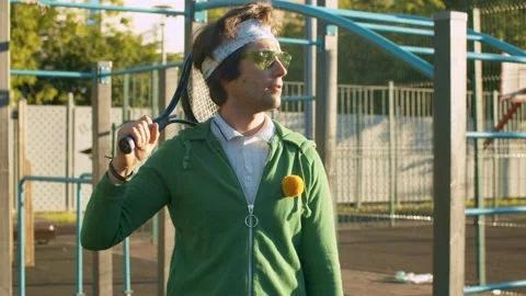 Funny freak man throws and catches tennis ball Stock Footage 133950688