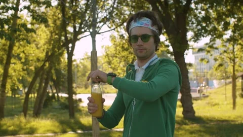Funny freak in the park drinking juice Stock Footage 133965135