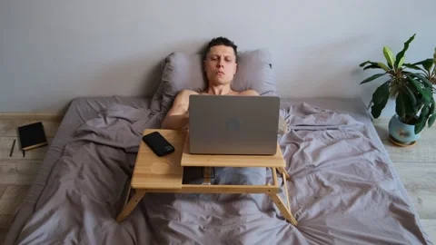 Funny freelancer dancing in bed while working on laptop humorous remote work Stock Footage 314515660