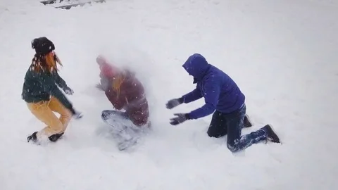 Funny friends playing in the snow on a bright winter day.Slow motion.Aerial shot Stock Footage 71505826